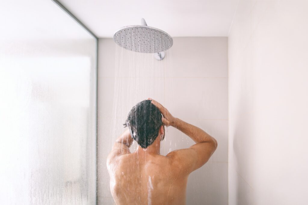 Man taking cold shower after sauna