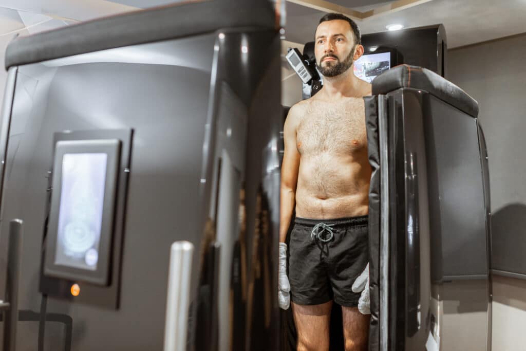 Man taking cryotherapy treatment vs cold plunge therapy